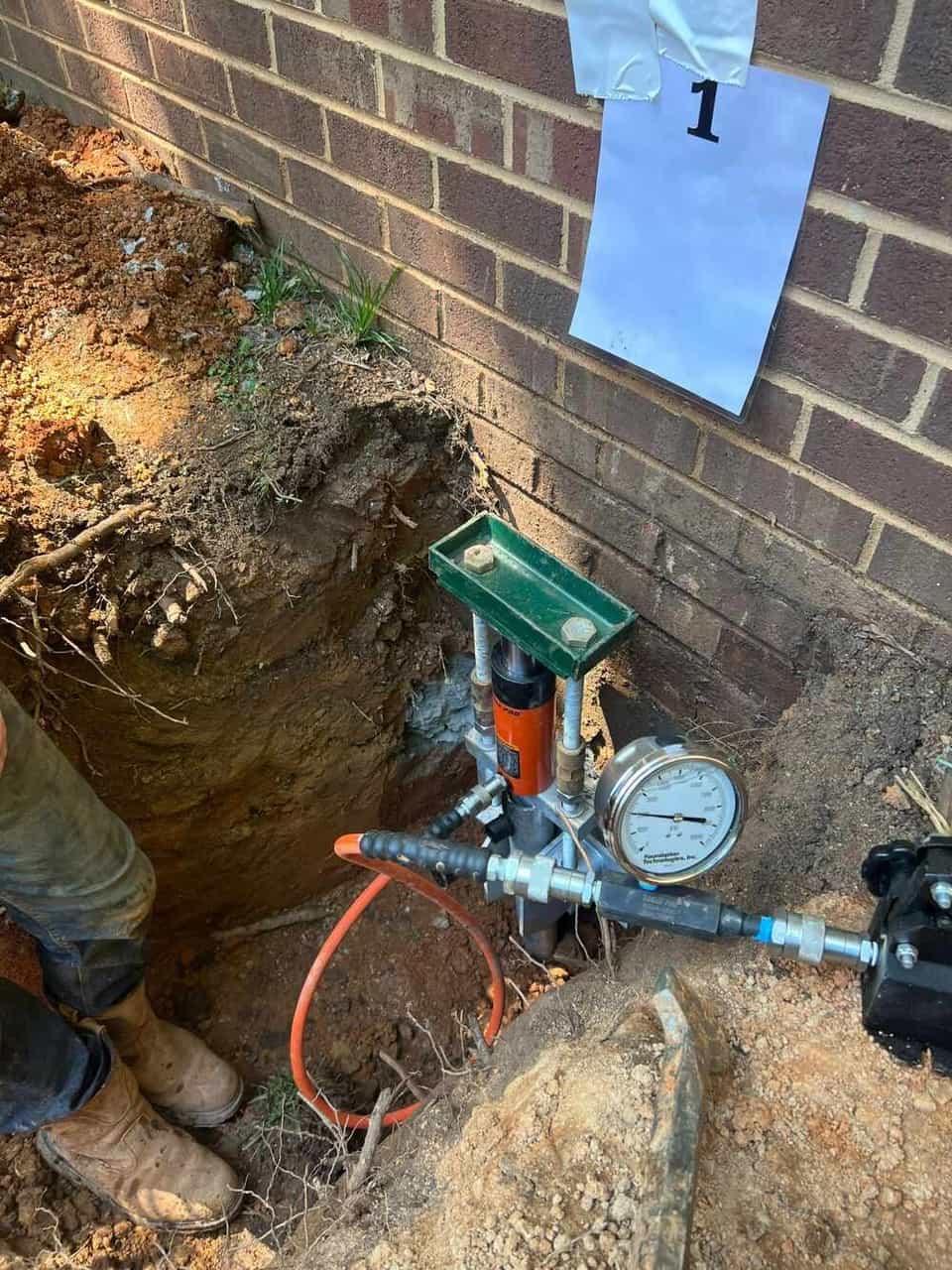 HydroHelp911 Crawl Space & Foundation Repair installing hydraulic push piers for foundation underpinning.