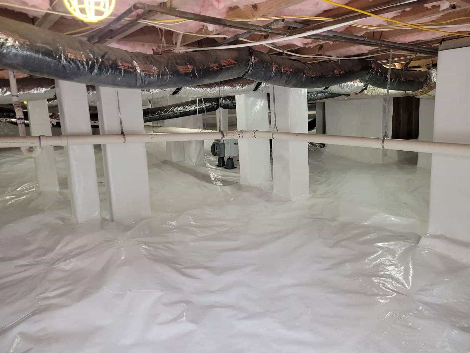 HydroHelp911 Crawl Space & Foundation Repair installing a white vapor barrier, dehumidifier, and insulation in a crawl space.