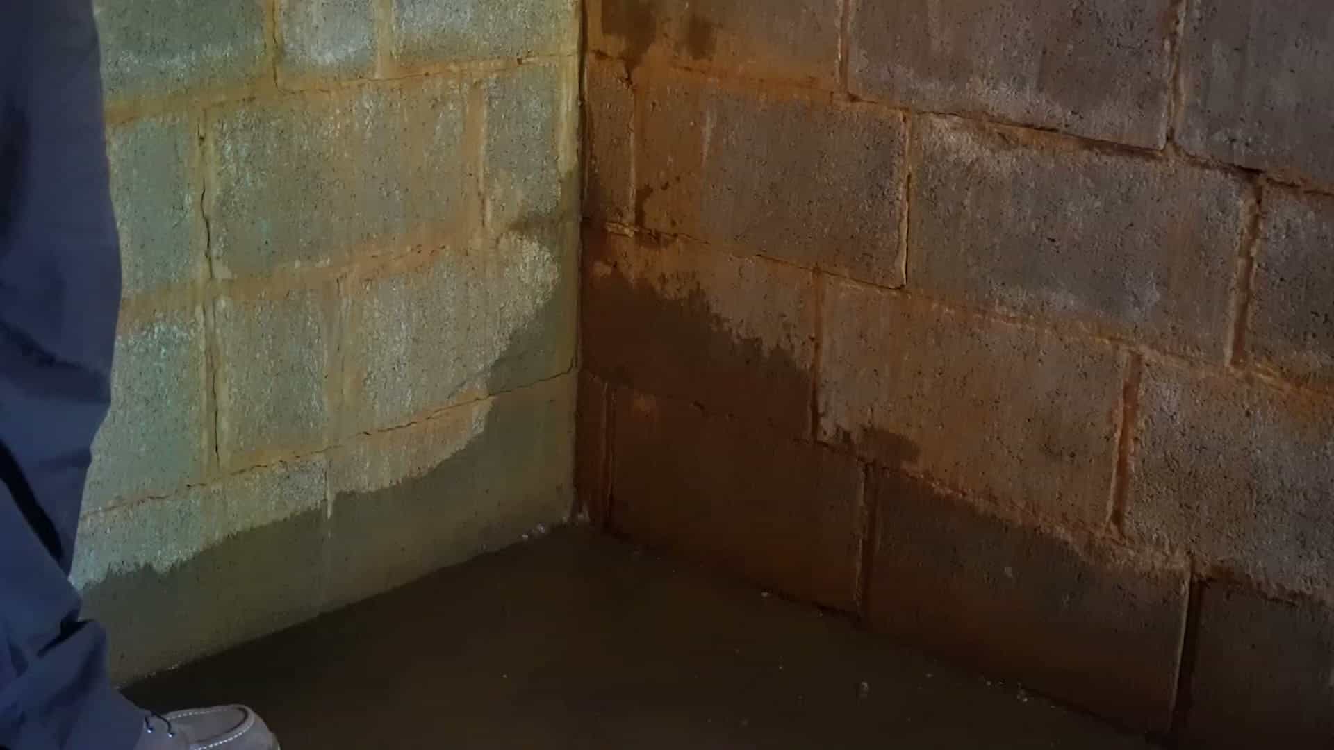 HydroHelp911 Crawl Space & Foundation Repair inspecting water in the basement cove and wet cinder block walls.