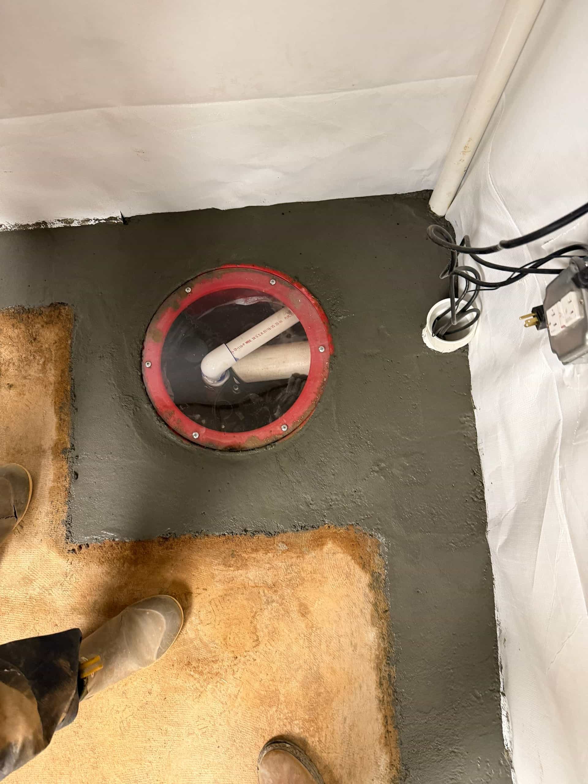 HydroHelp911 Crawl Space & Foundation Repair installing a new sump pump in a basement with a vapor barrier