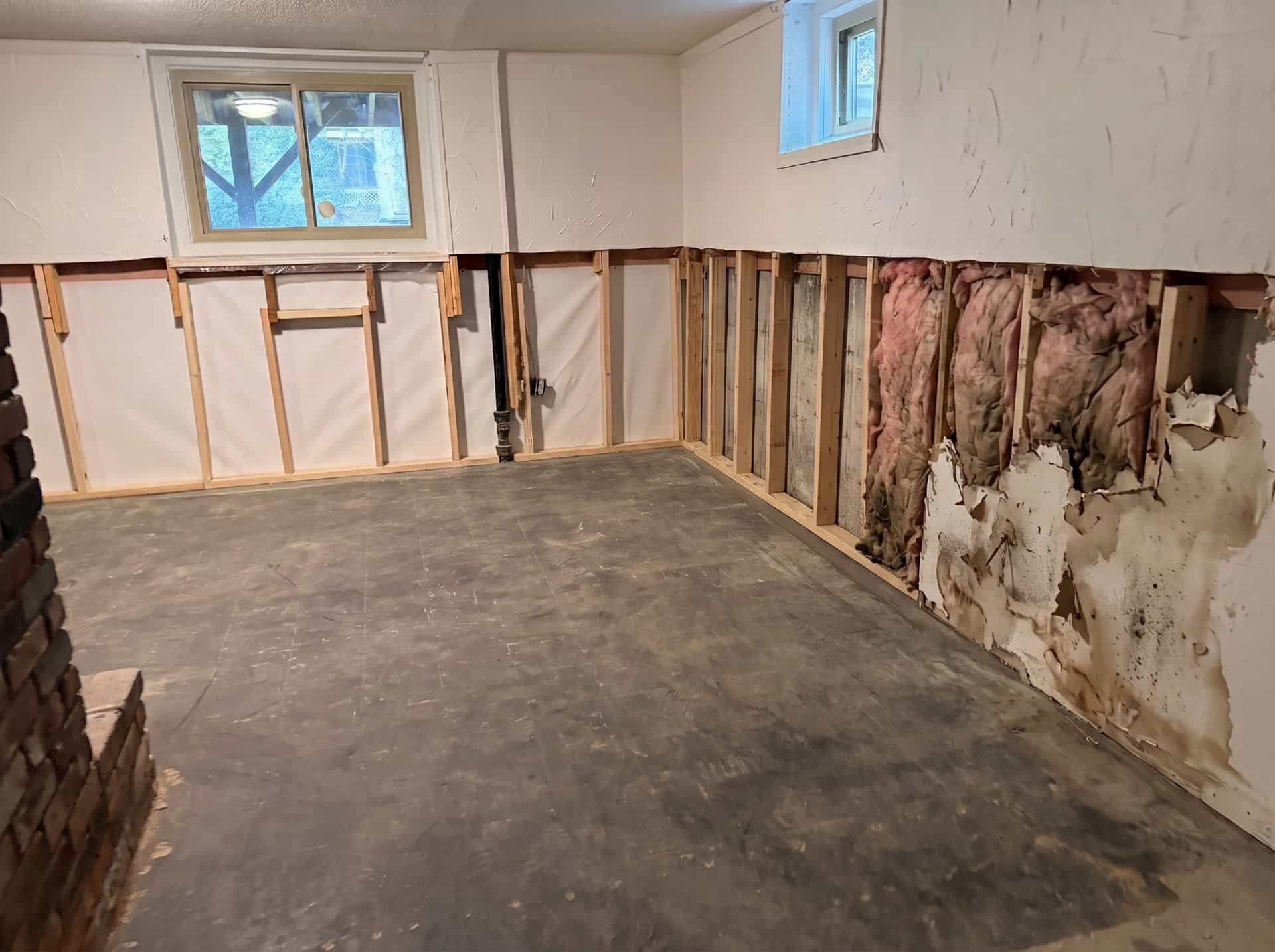 HydroHelp911 Crawl Space & Foundation Repair inspecting severely water damaged basement drywall and insulation.