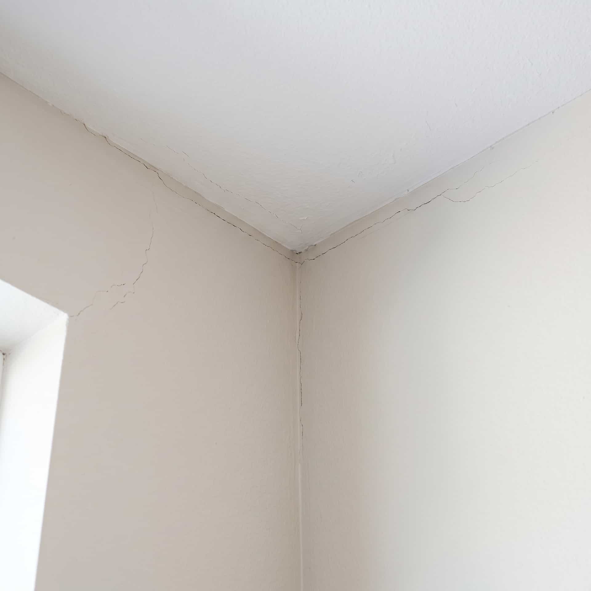 HydroHelp911 Crawl Space & Foundation Repair inspecting diagonal cracks in drywall, ceiling, and door frame.