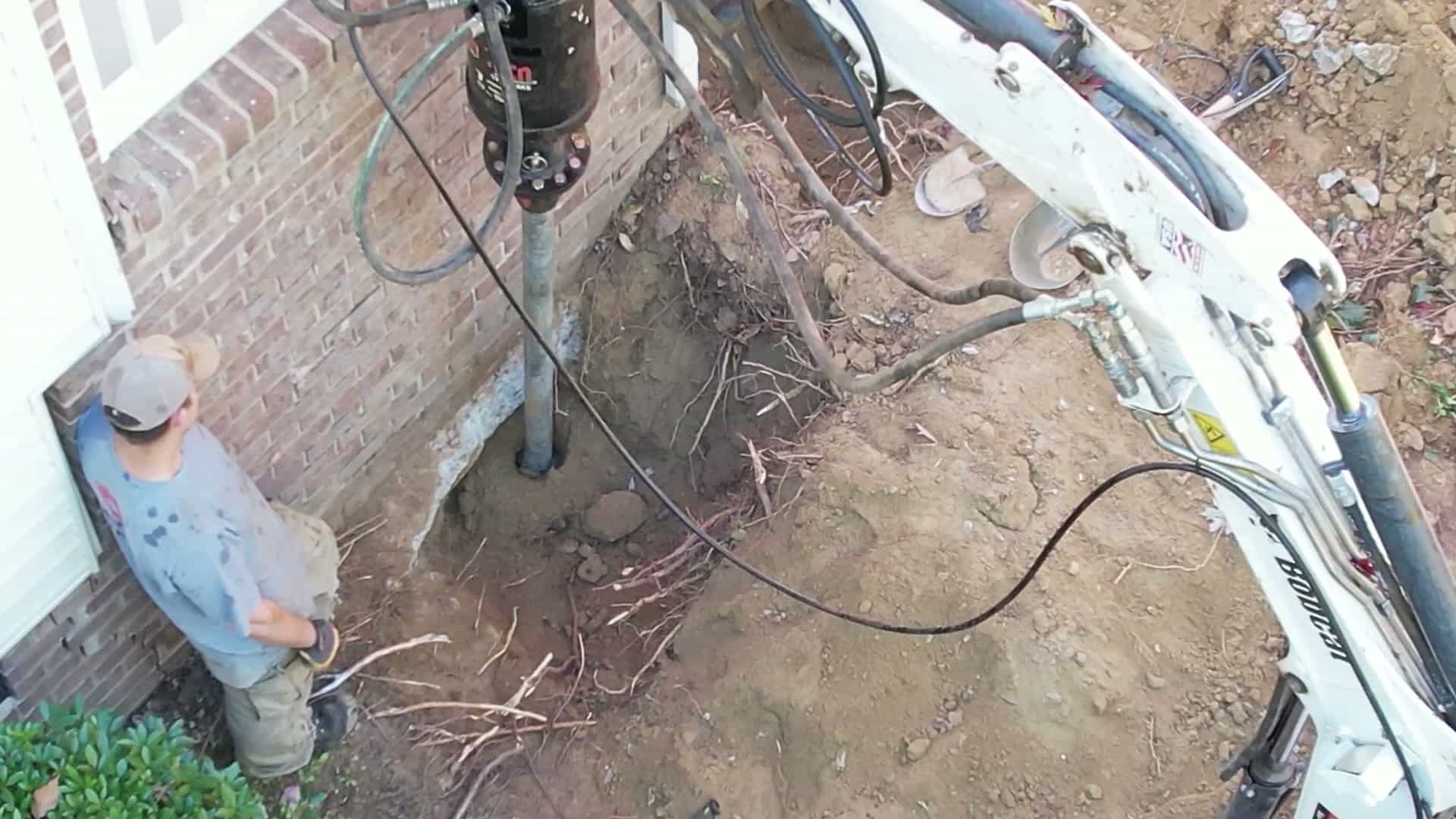 HydroHelp911 Crawl Space & Foundation Repair installing steel helical piers for foundation underpinning