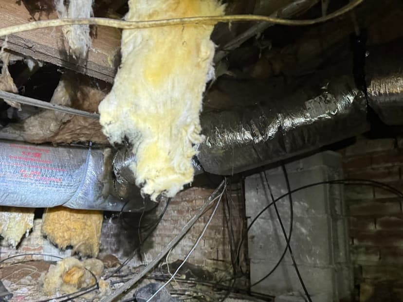Insulation hanging down from between the floor joists of a crawl space