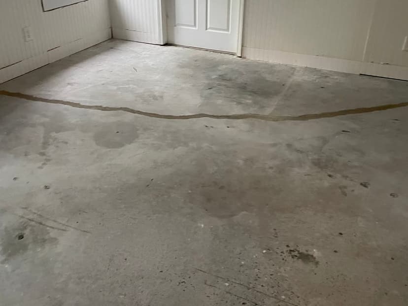 A long crack across a concrete slab floor, filled with sealant