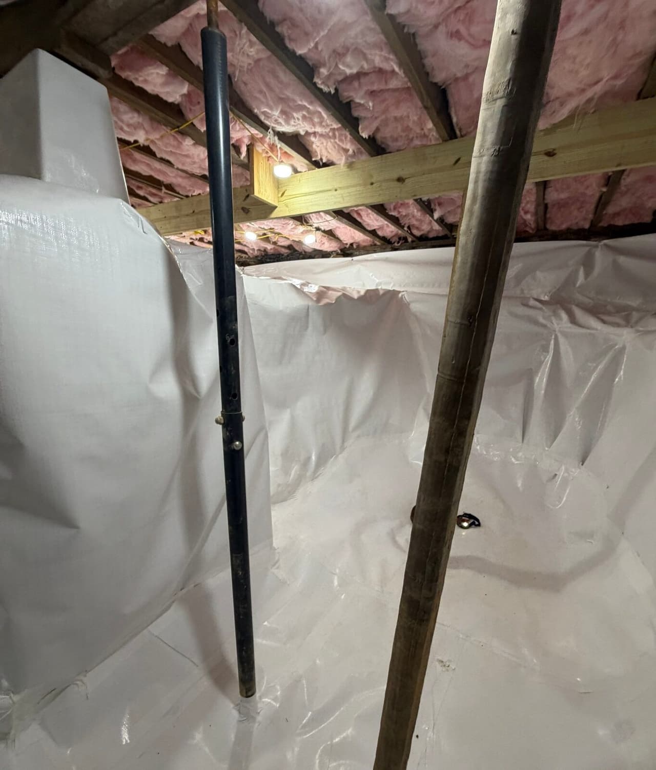 Lined crawl space with a wrapped pier, a metal support post and a wood post under a new beam.