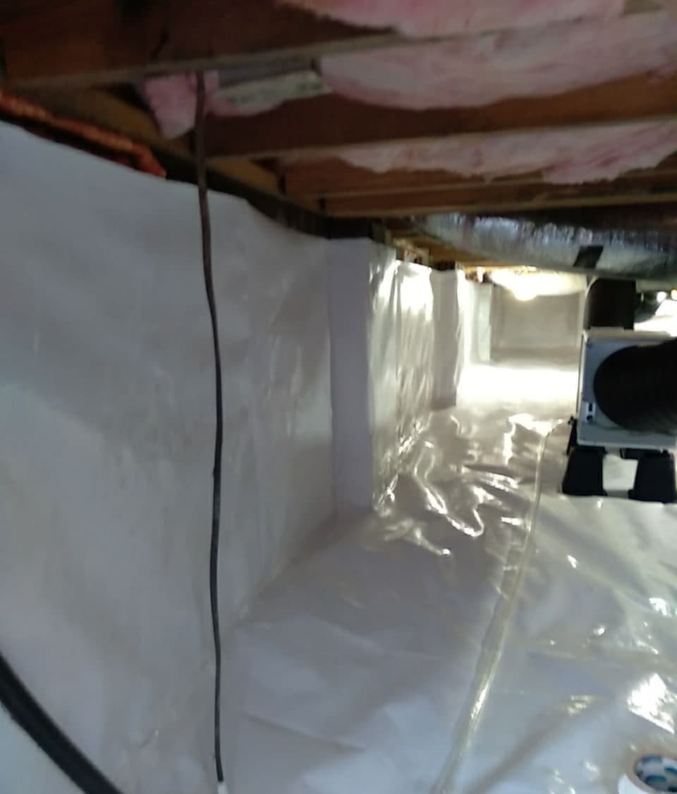 Crawl space liner covering the walls and floor, with the dehumidifier set on the liner.