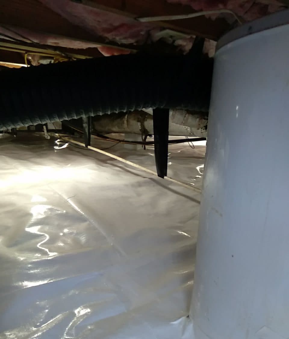 White crawl space liner covering the floor and wrapped up a tank at the right.