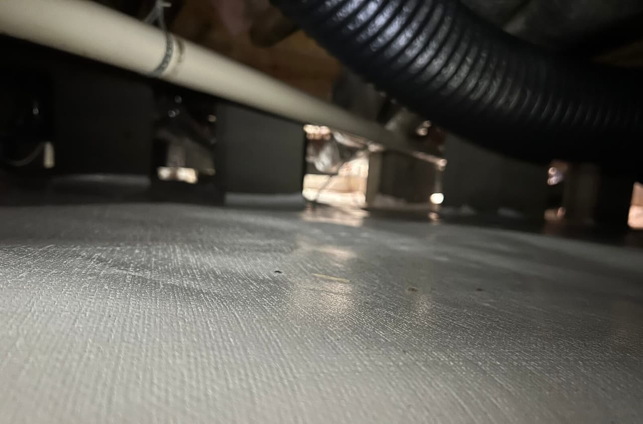 Close view of the crawl space liner over the floor.