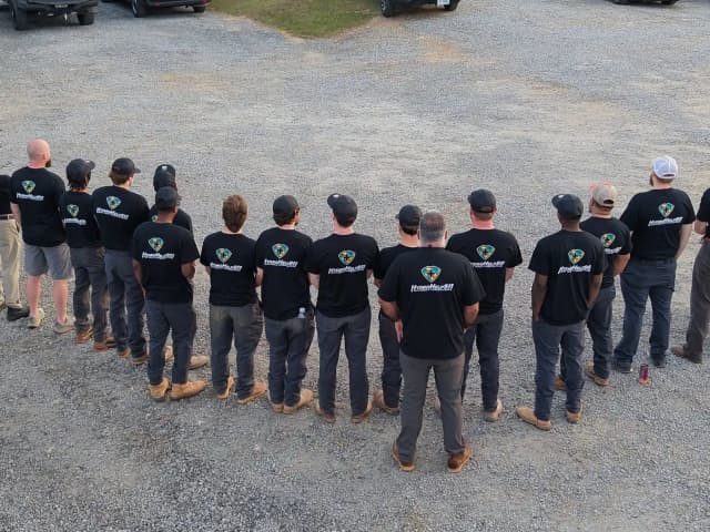 HydroHelp911 Crawl Space & Foundation Repair team members standing together in branded black shirts.