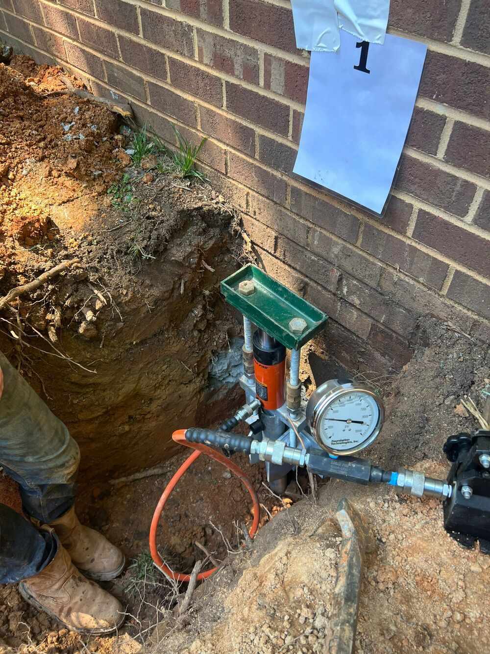 HydroHelp911 Crawl Space & Foundation Repair installing hydraulic push piers for foundation underpinning.