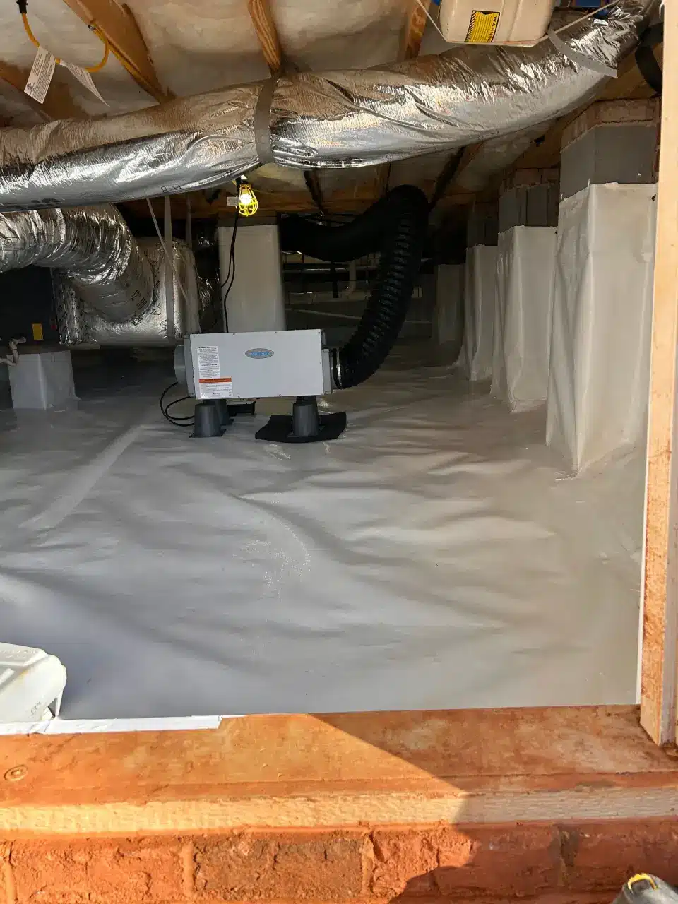 HydroHelp911 Crawl Space & Foundation Repair installing a crawl space dehumidifier and vapor barrier.
