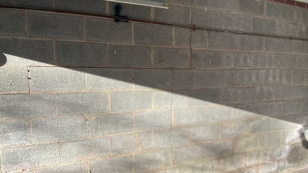 HydroHelp911 Crawl Space & Foundation Repair inspecting a horizontal crack in a concrete block basement wall.