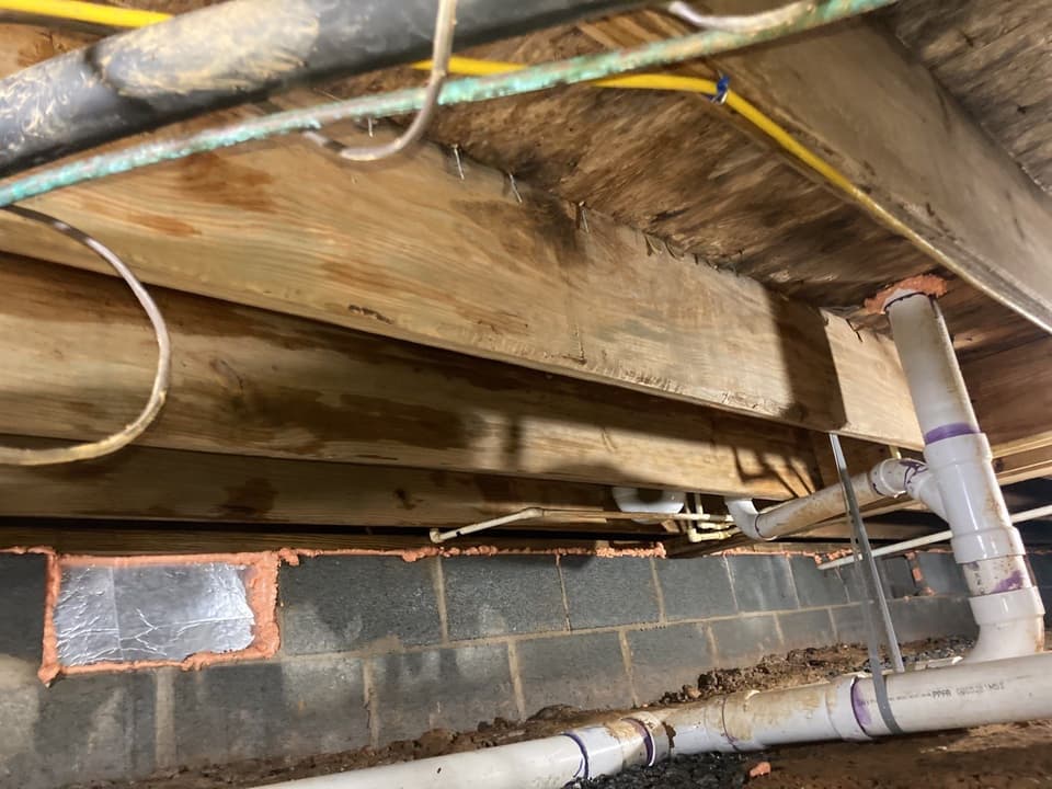 HydroHelp911 Crawl Space & Foundation Repair sealing vents and penetrations in a crawl space with exposed joists.