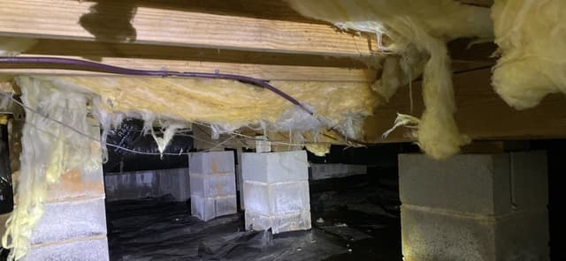 HydroHelp911 Crawl Space & Foundation Repair inspecting deteriorating insulation and efflorescence in a crawl space.