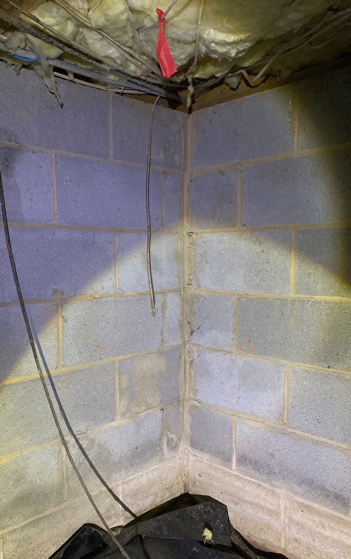 HydroHelp911 Crawl Space & Foundation Repair inspecting efflorescence and a vertical crack on a concrete block wall