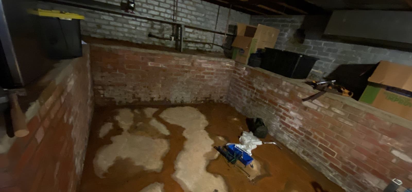 HydroHelp911 Crawl Space & Foundation Repair inspecting basement flooding with wet walls and efflorescence.