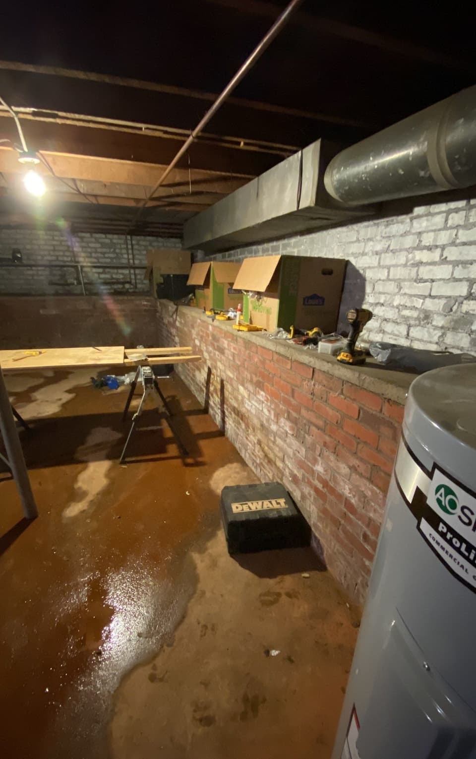 HydroHelp911 Crawl Space & Foundation Repair inspecting pooled water and wet walls in a basement.