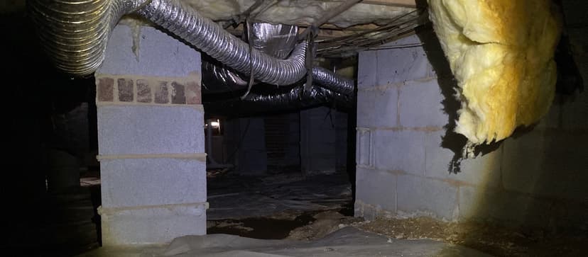 HydroHelp911 Crawl Space & Foundation Repair inspecting standing water and deteriorating insulation in a damp crawl space.