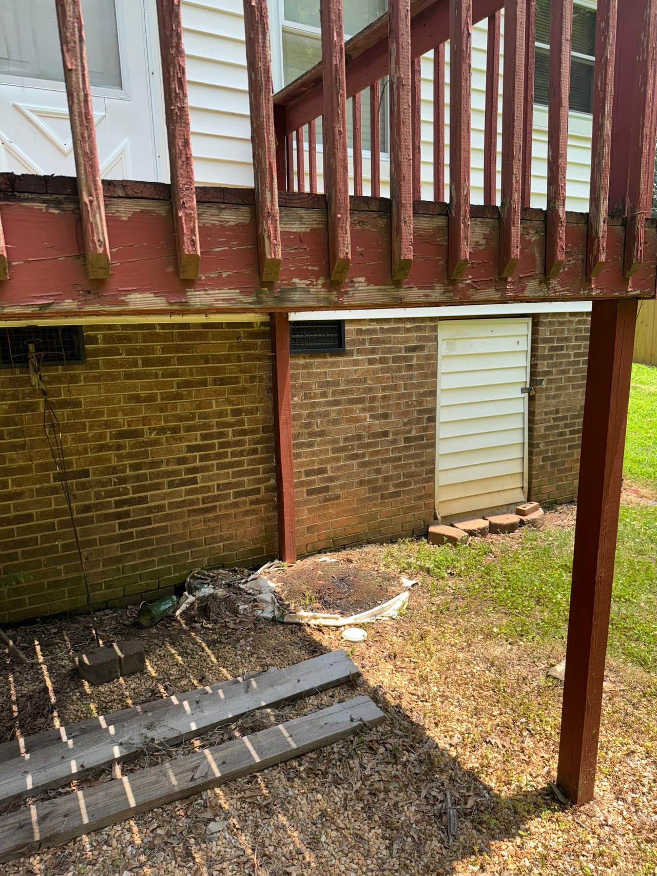 HydroHelp911 Crawl Space & Foundation Repair inspecting an exterior crawl space with vents and an access door.