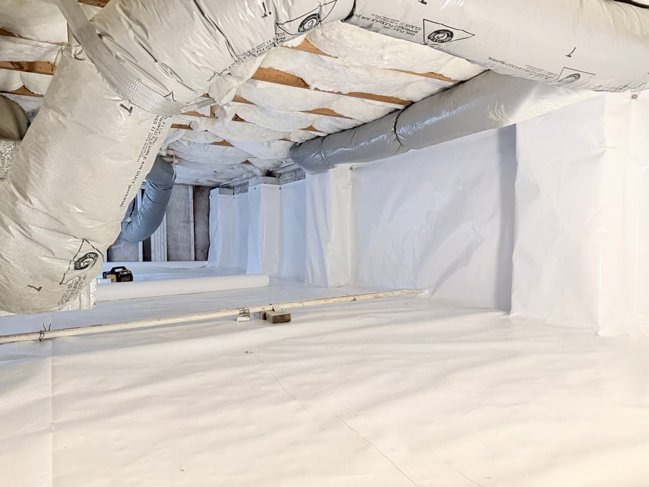 HydroHelp911 Crawl Space & Foundation Repair crew installing a vapor barrier for crawl space encapsulation.
