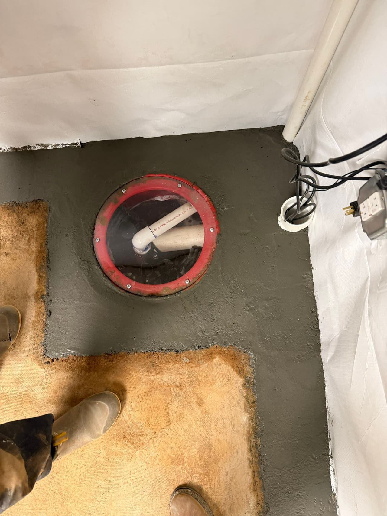 HydroHelp911 Crawl Space & Foundation Repair installing a new sump pump in a basement with a vapor barrier