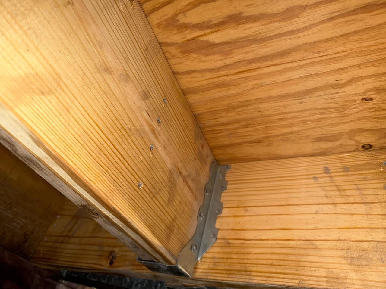 HydroHelp911 Crawl Space & Foundation Repair installing joist hangers on floor joists in a crawl space.