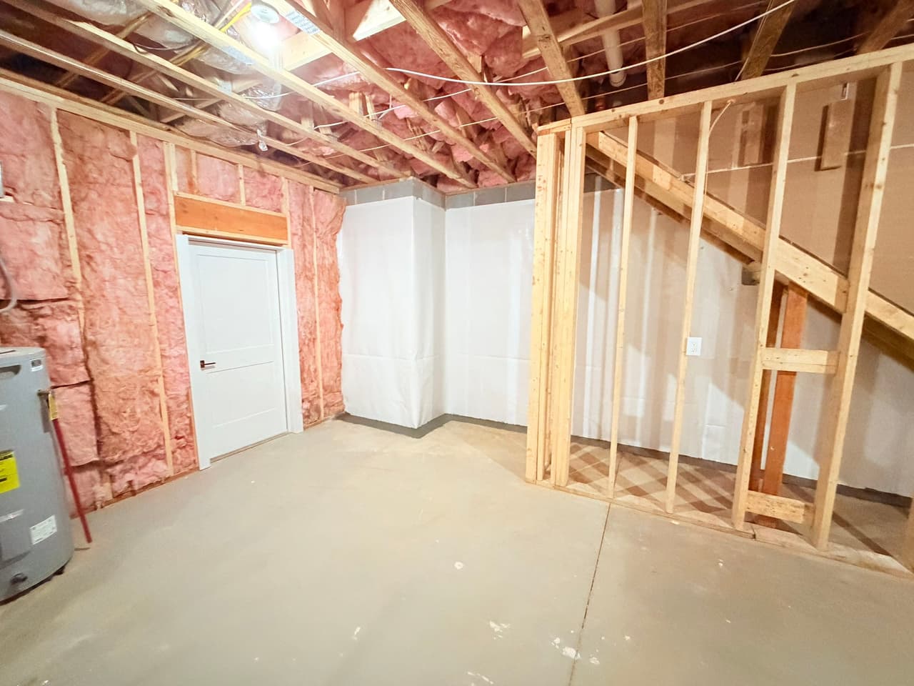 HydroHelp911 Crawl Space & Foundation Repair installing vapor barrier and insulation in an unfinished basement.