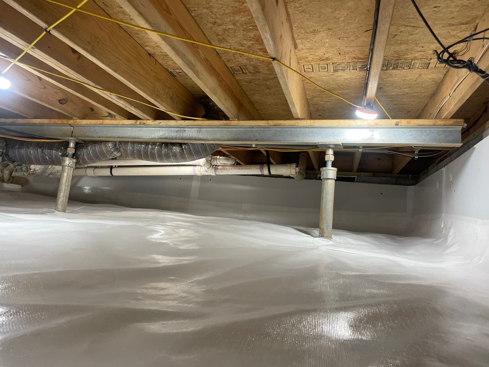 HydroHelp911 Crawl Space & Foundation Repair installing a vapor barrier and adjustable steel jacks in a crawl space.