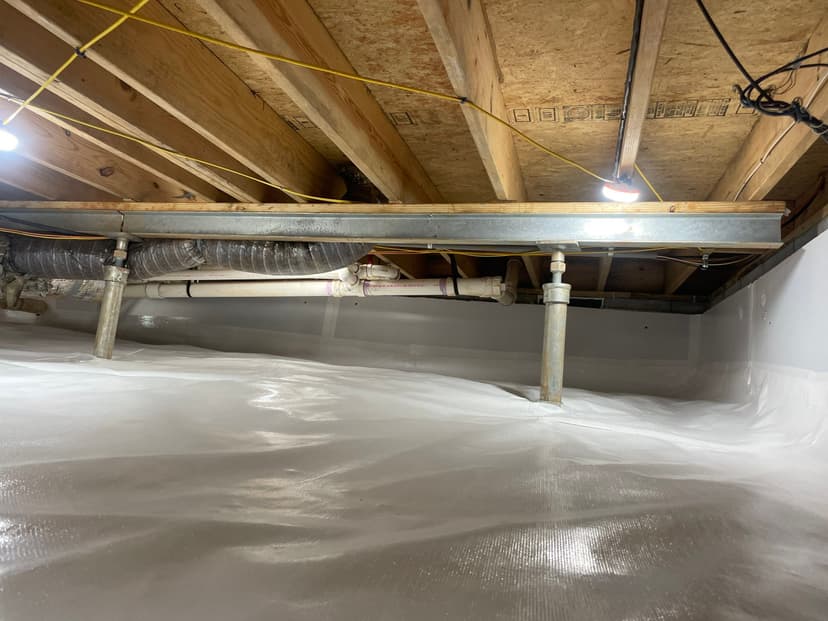 HydroHelp911 Crawl Space & Foundation Repair installing a vapor barrier and adjustable steel jacks in a crawl space.