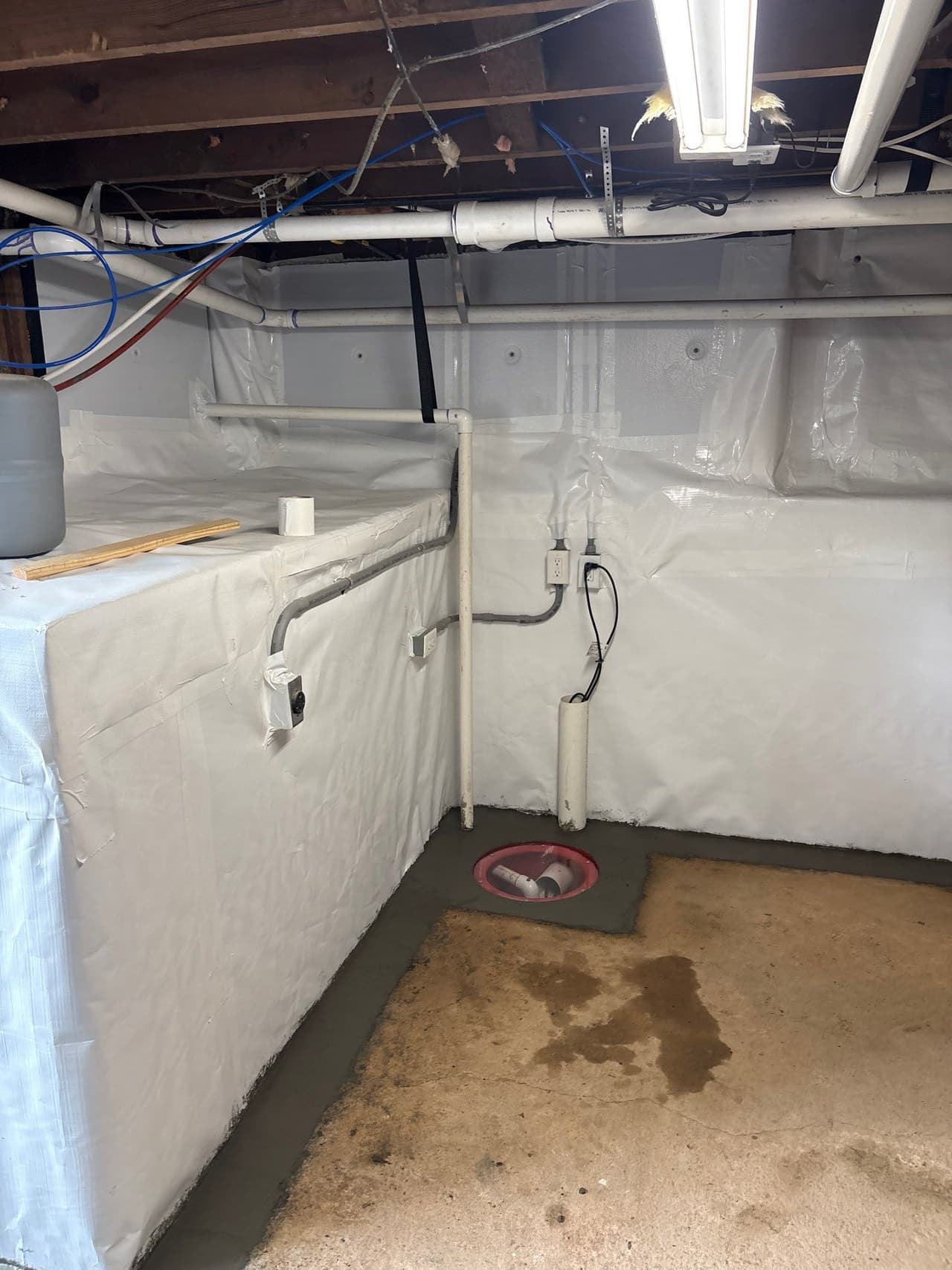 HydroHelp911 Crawl Space & Foundation Repair installing a sump pump with an interior drainage system and vapor barrier.