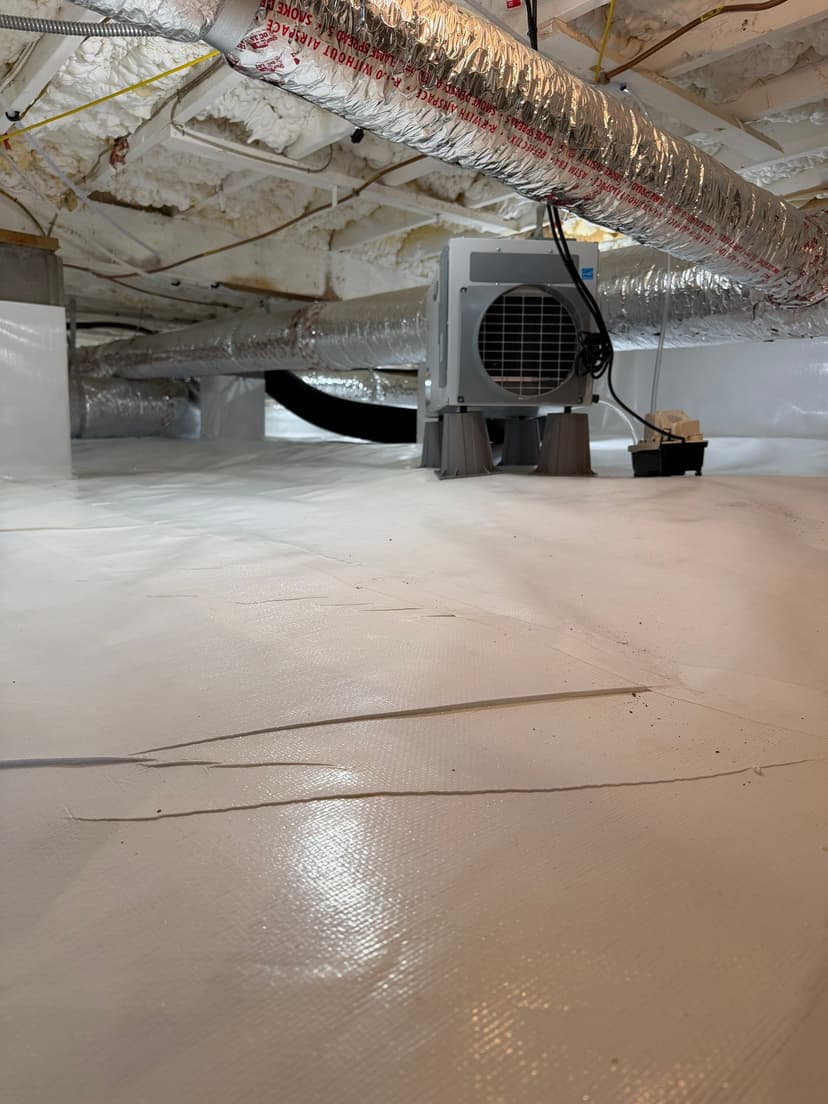 HydroHelp911 Crawl Space & Foundation Repair installing a dehumidifier and vapor barrier in a clean encapsulated crawl space.