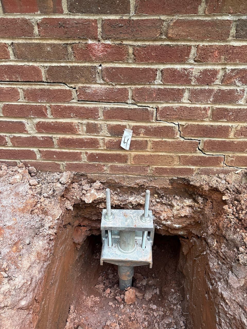 HydroHelp911 Crawl Space & Foundation Repair installing steel piers with footing brackets to repair a foundation.