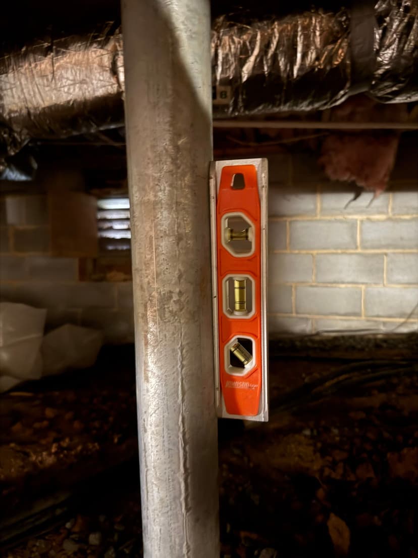 HydroHelp911 Crawl Space & Foundation Repair adjusting a crawl space support jack with a level tool.