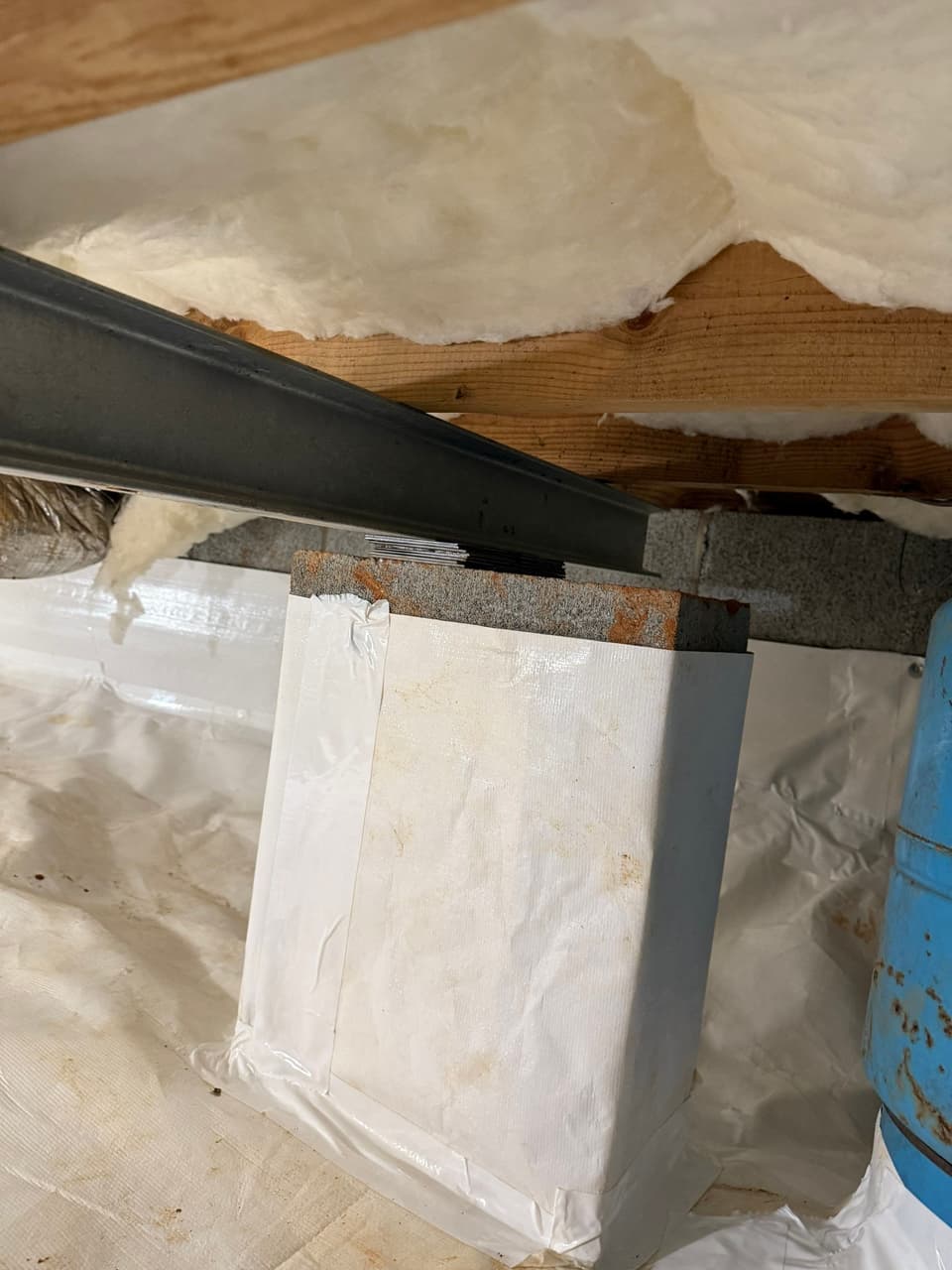 HydroHelp911 Crawl Space & Foundation Repair installing insulation and a vapor barrier in a crawl space with exposed joists.
