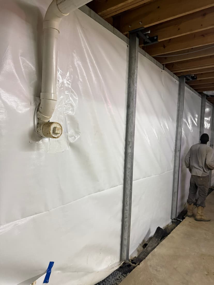 HydroHelp911 Crawl Space & Foundation Repair installing an interior drainage system and vapor barrier in a crawl space.