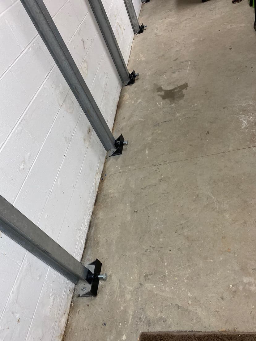 HydroHelp911 Crawl Space & Foundation Repair installing steel I-beam wall bracing in a basement to stabilize bowing walls.