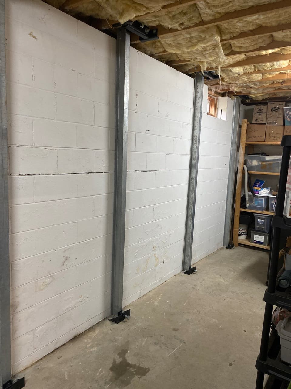 HydroHelp911 Crawl Space & Foundation Repair installing i-beam wall bracing to stabilize a bowing basement foundation wall.