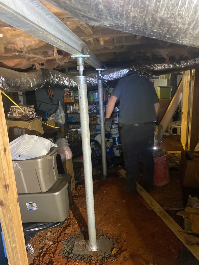 HydroHelp911 Crawl Space & Foundation Repair technician installing adjustable steel jacks to support a crawl space.