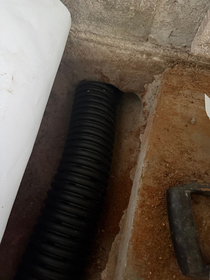 HydroHelp911 Crawl Space & Foundation Repair installing a black interior drainage system in a drainage trench.