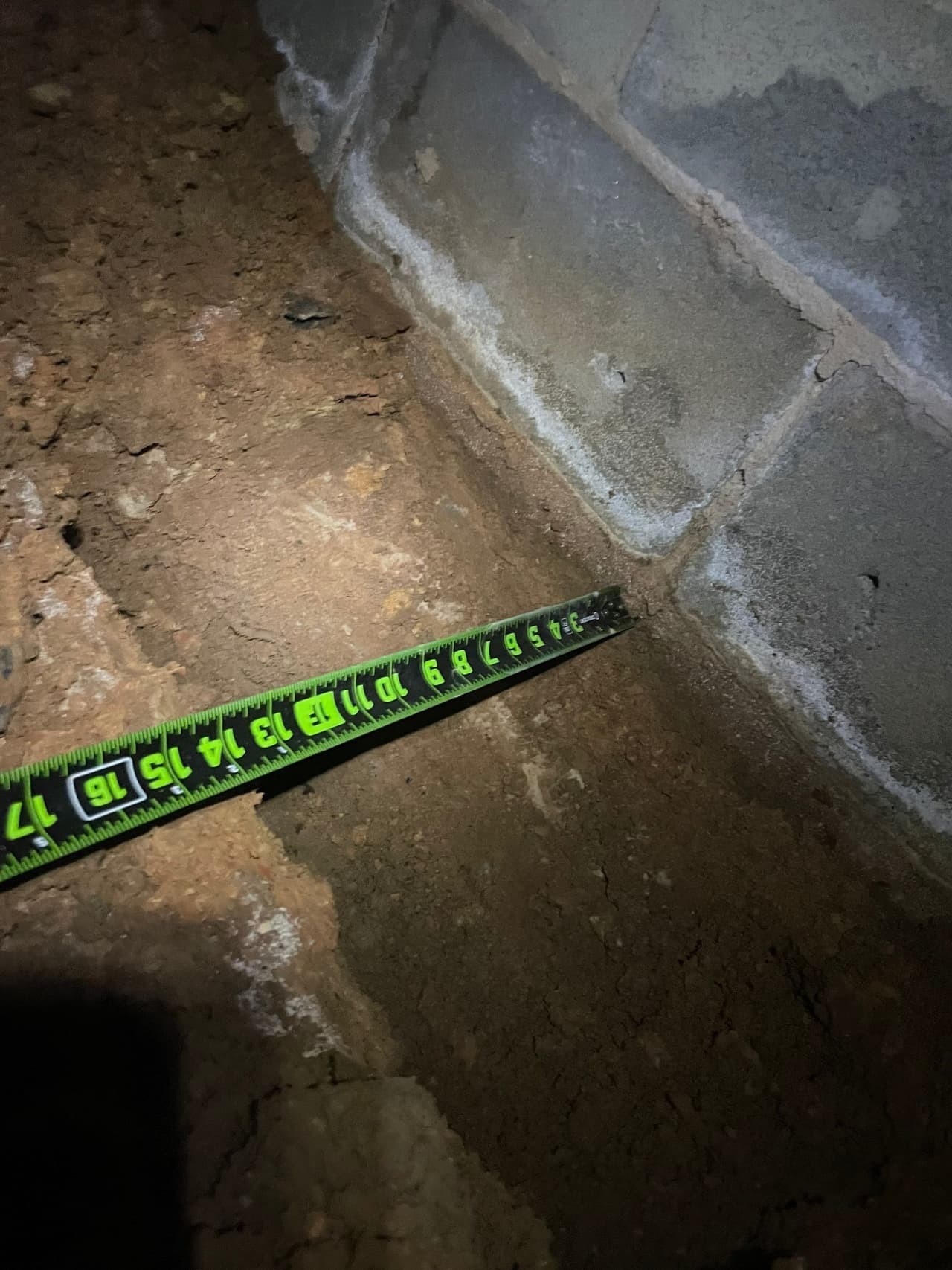 HydroHelp911 Crawl Space & Foundation Repair inspecting efflorescence on a cinder block foundation wall.
