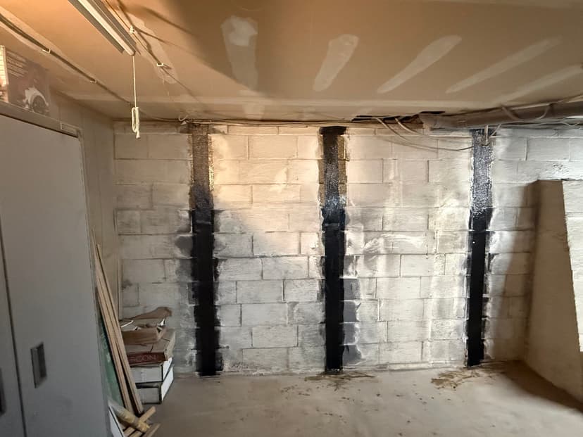 HydroHelp911 Crawl Space & Foundation Repair installing carbon fiber reinforcement on a bowing basement wall.