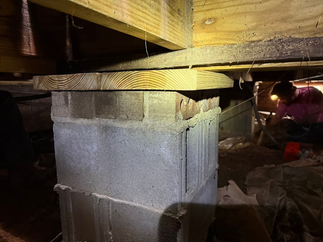 HydroHelp911 Crawl Space & Foundation Repair stabilizing floor joists with a wooden beam on a block pier in a crawl space.