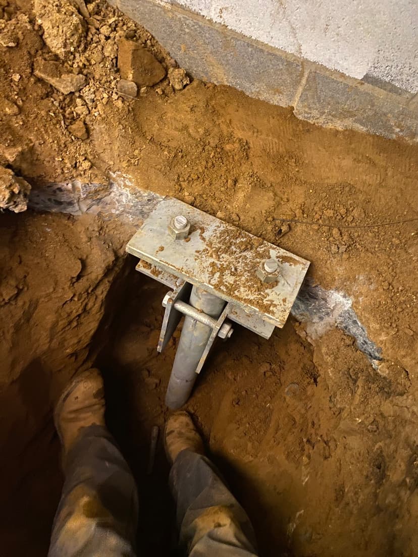 HydroHelp911 Crawl Space & Foundation Repair installing steel piers for concrete slab foundation underpinning.