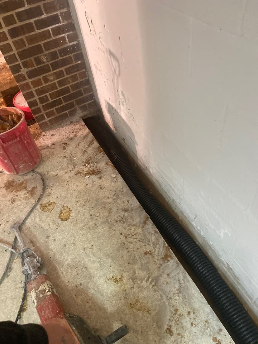 HydroHelp911 Crawl Space & Foundation Repair installing an interior drainage system in a basement.