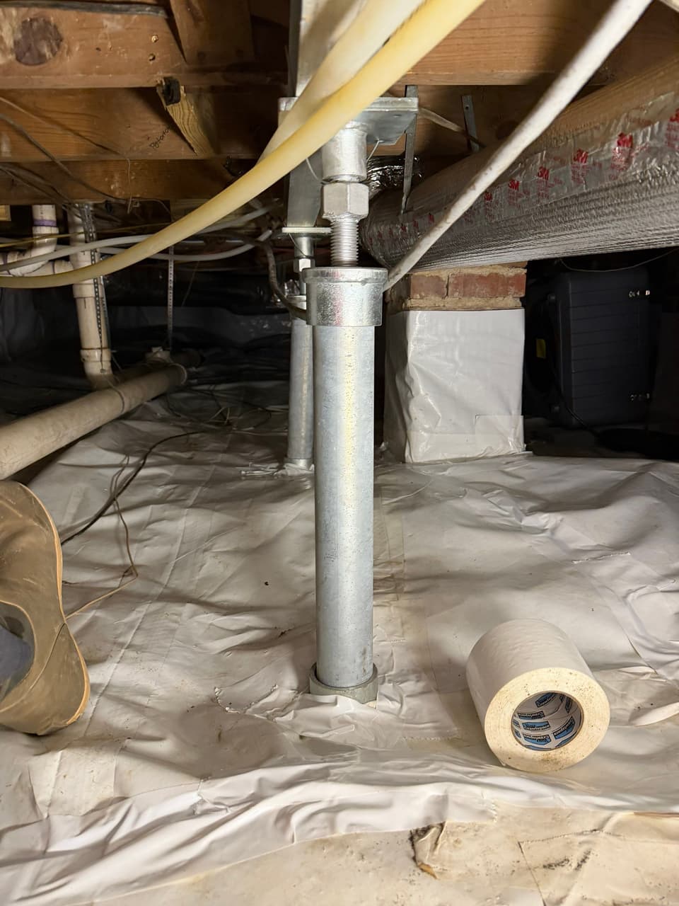 HydroHelp911 Crawl Space & Foundation Repair installing crawl space jacks and vapor barrier in a crawl space.