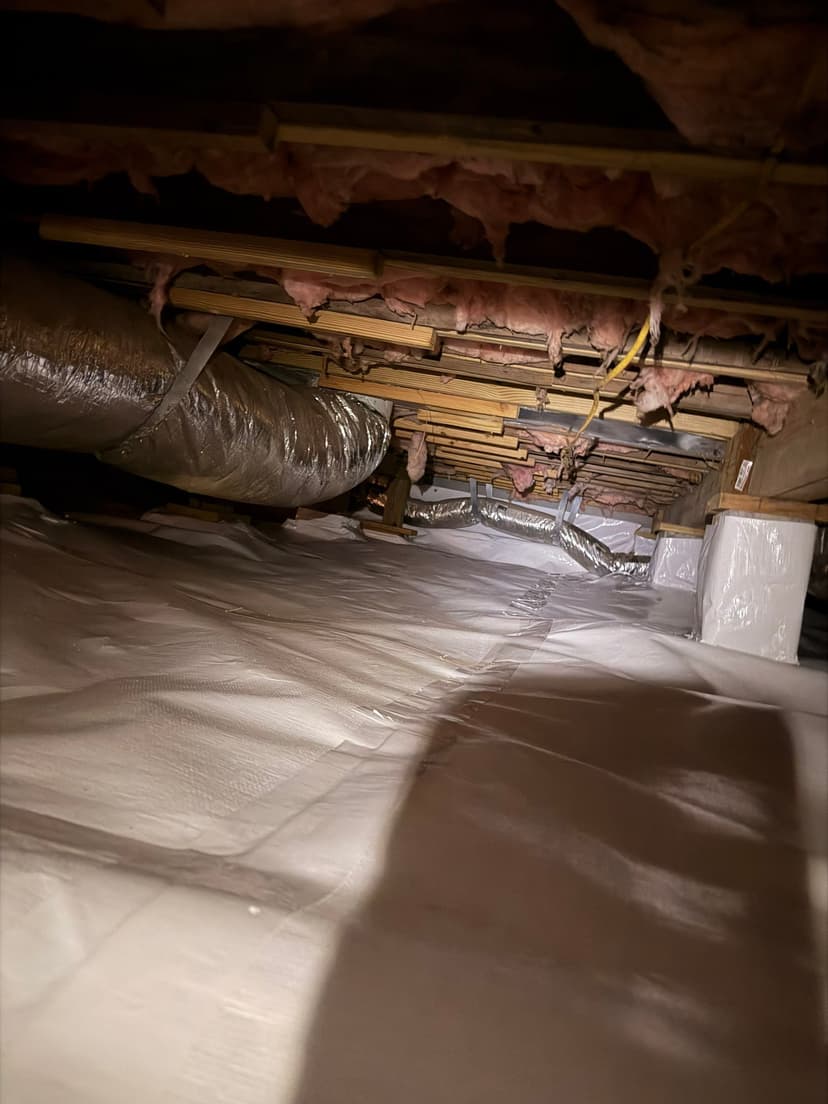 HydroHelp911 Crawl Space & Foundation Repair crew repairing a crawl space with a vapor barrier and deteriorating insulation.