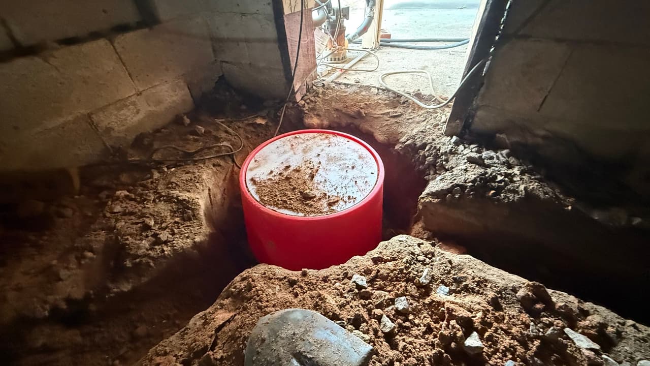 HydroHelp911 Crawl Space & Foundation Repair installing a sump pump basin in a crawl space.