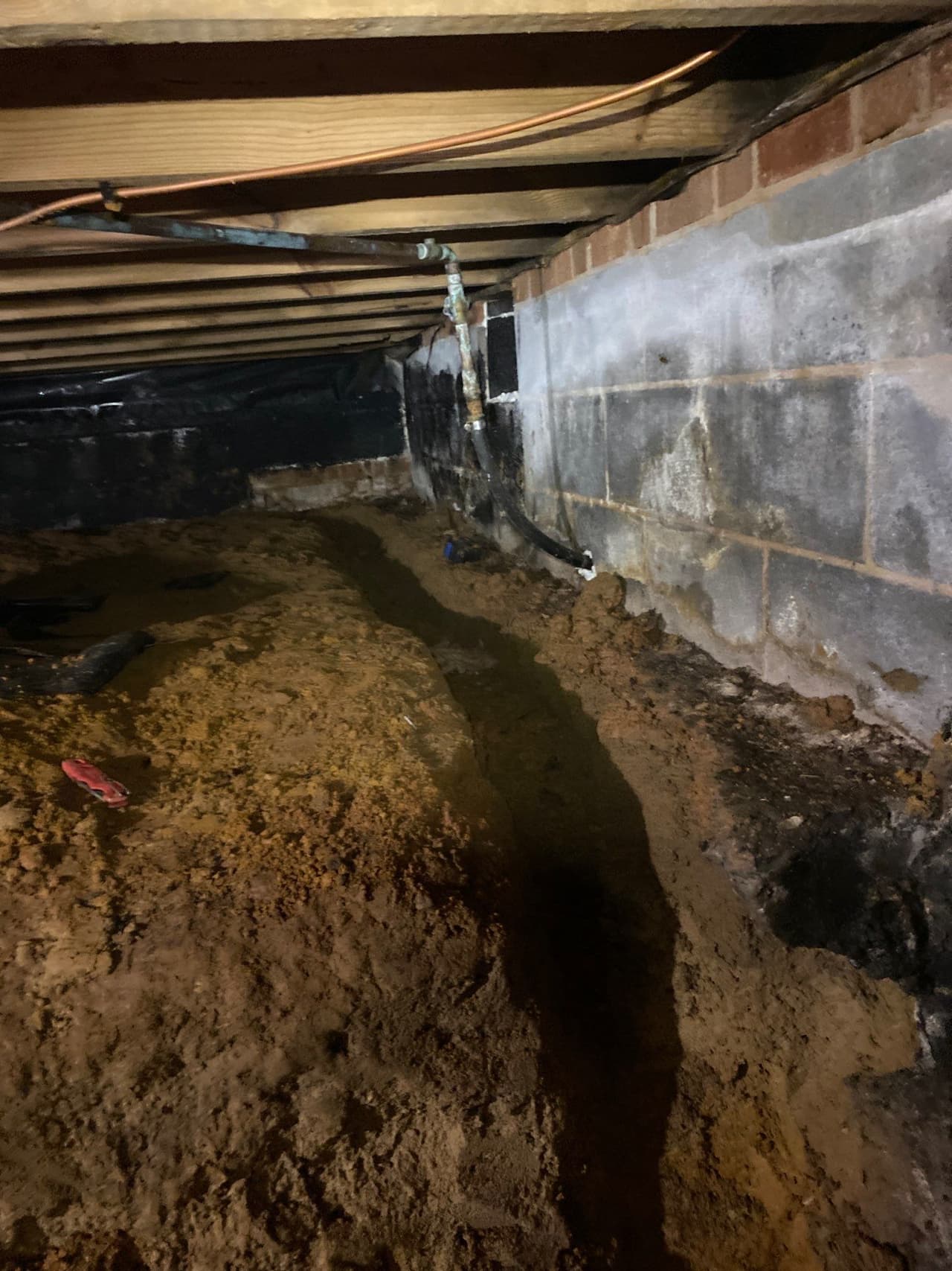 HydroHelp911 Crawl Space & Foundation Repair installing a drainage trench in a crawl space.
