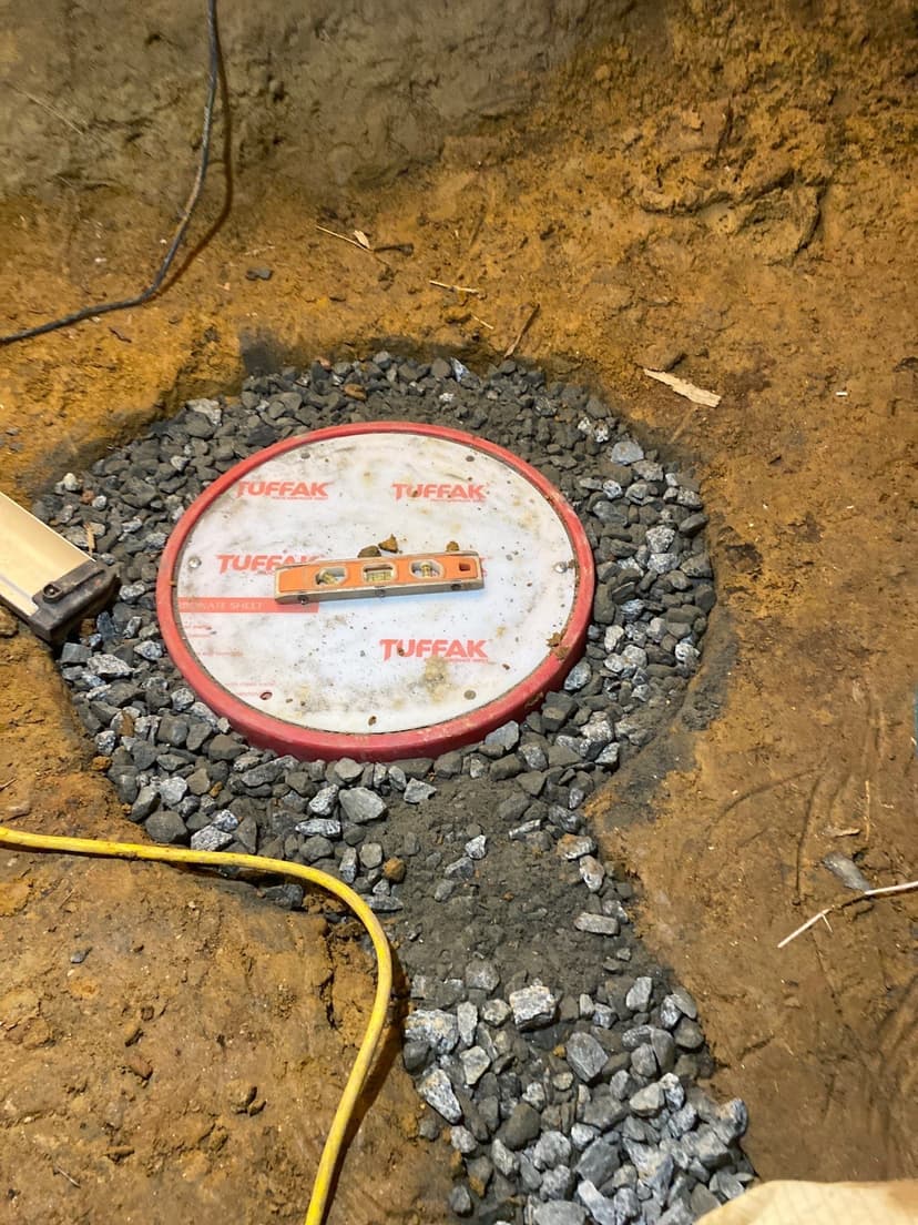 HydroHelp911 Crawl Space & Foundation Repair installing a sump pump pit with drainage gravel in a crawl space.